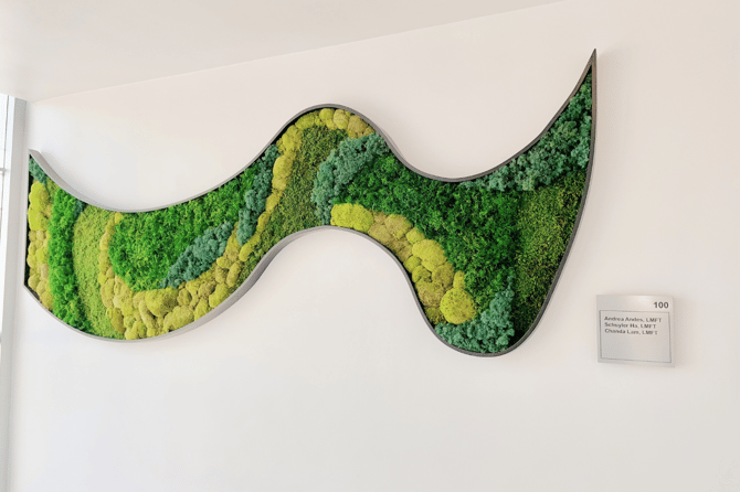 A moss wall in a squiggly design mounted on a wall 