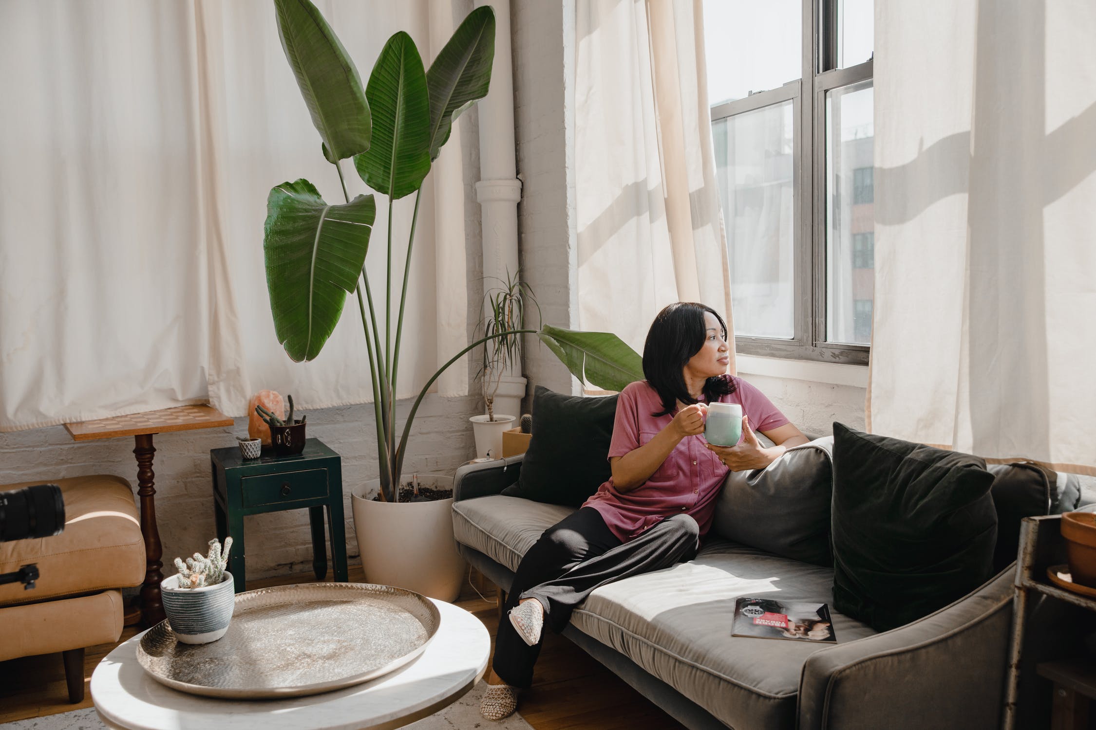 Lady sits peacefully in her lounge with plants.